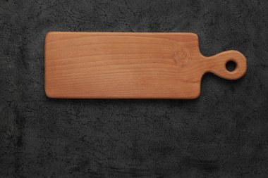 Kahverengi tahta kesme tahtası, siyah taş masanın üzerinde. Kopyalama alanı olan üst görünüm. Kırsal yemekler.