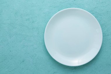 Mavi çimento arka planında boş mavi seramik tabak. Üst görünüm, alanı kopyala