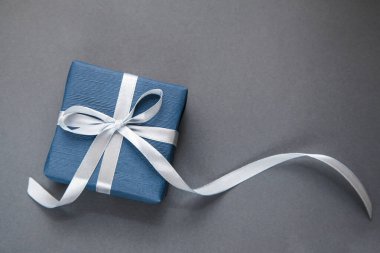 Gri arka planda koyu mavi hediye kutusu. Erkekler için bir hediye. Babalar Günü. Onun için hediye..