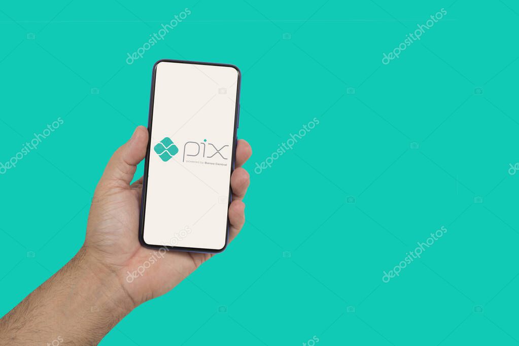 Ribeiro Preto, So  Paulo, Brazil, 10-27-2020-  hand holding smartphone, showing the pix application logo (bank transfer application, used in brazil)