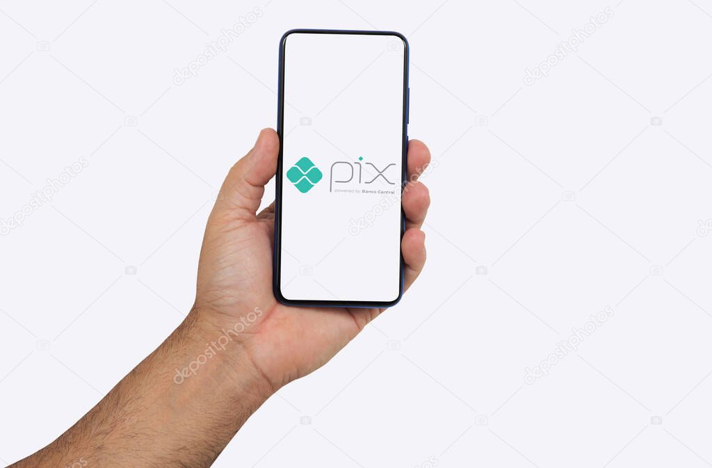 Ribeiro Preto, So  Paulo, Brazil, 10-27-2020-  hand holding smartphone, showing the pix application logo (bank transfer application, used in brazil)