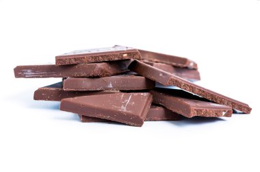 Çatlak çikolata blokları beyaz arkaplanda yığılıyor