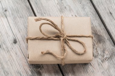 Vintage hediye kutusu kahverengi kağıt ahşap arka plan üzerinde ip ile sarılmış
