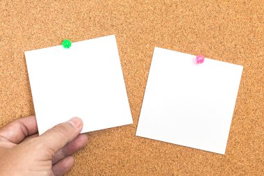 Boş beyaz kağıt bir not, mantar üzerinde yeşil bir iğne ve el ele tutuşmalar.