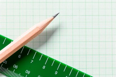 Yeşil grafik kağıdında kopya alanı olan kalem ve cetvel