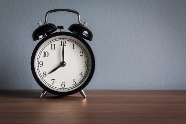 Ahşap masanın üzerinde klasik çalar saati olan sakin bir hayat (çalar saat 8 'i gösteriyor) )