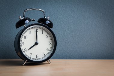 Ahşap masanın üzerinde klasik çalar saati olan sakin bir hayat (çalar saat 8 'i gösteriyor) )