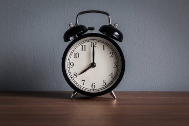Ahşap masanın üzerinde klasik çalar saati olan sakin bir hayat (çalar saat 8 'i gösteriyor) )