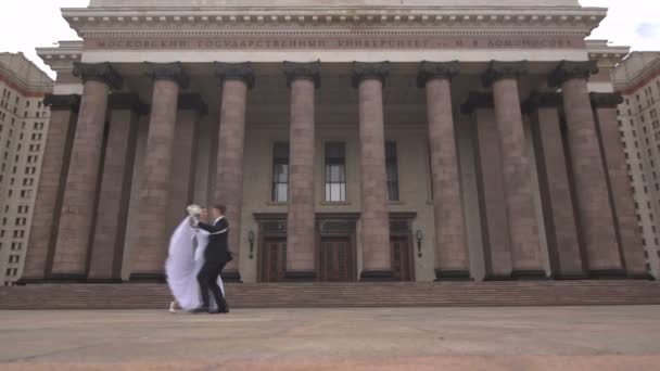 Bride and groom dancing on the background of columns — Stock Video