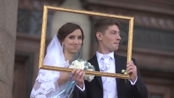 Jeunes mariés dans un cadre photo — Video