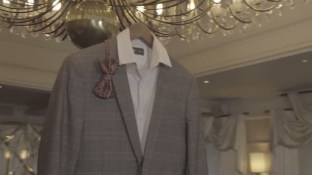 Camisa, um casaco e uma borboleta pendurados no lustre — Vídeo de Stock
