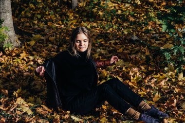 Genç bayan sonbahar manzarası kırmızı akçaağaç yaprakları, turuncu örülmüş sıcak bir süveter