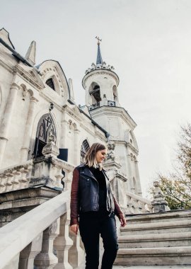 Büyük taş merdivenlerde dikilen kadın eski tarihi tapınak kalesi kilise inşa ediyor. 