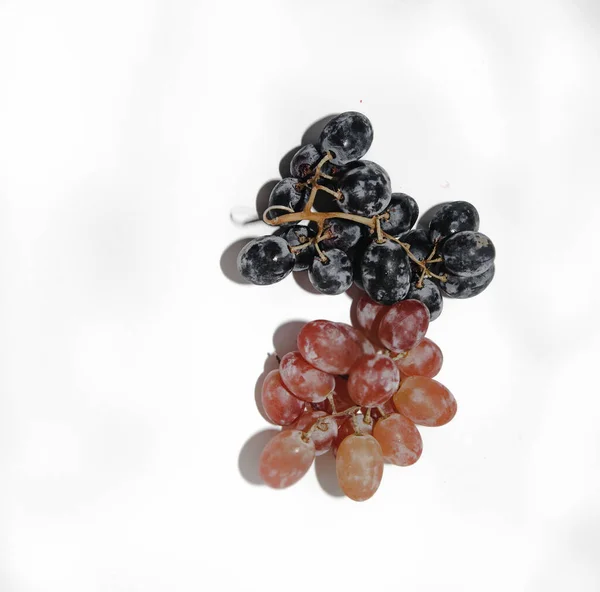 Dos tipos de uvas sobre un fondo blanco con un lugar para tex —  Fotos de Stock