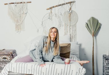 Bej takım elbiseli, uzun saçlı genç ve güzel bir kadın model. Noel ağacı.