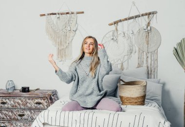 Bej takım elbiseli, uzun saçlı genç ve güzel bir kadın model. Noel ağacı.