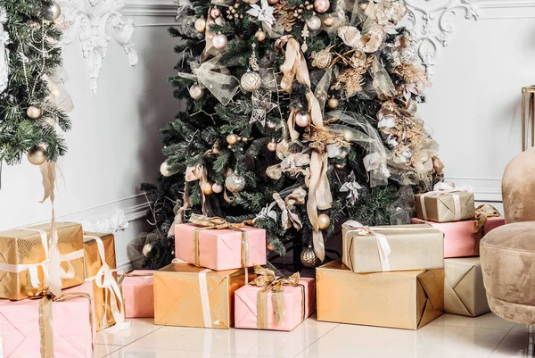 Mooie grote kerstboom versierd met ballen en speelgoed vakantie kerststemming geschenken met linten — Stockfoto