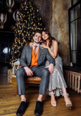 Genç çiftler yeni evliler güler, sevinirler Noel havasına girerler şefkatle sarılırlar, Noel öpücüğünü severler.