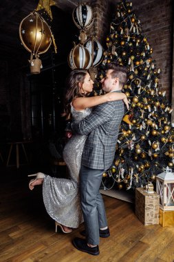 Genç çiftler yeni evliler güler, sevinirler Noel havasına girerler şefkatle sarılırlar, Noel öpücüğünü severler.