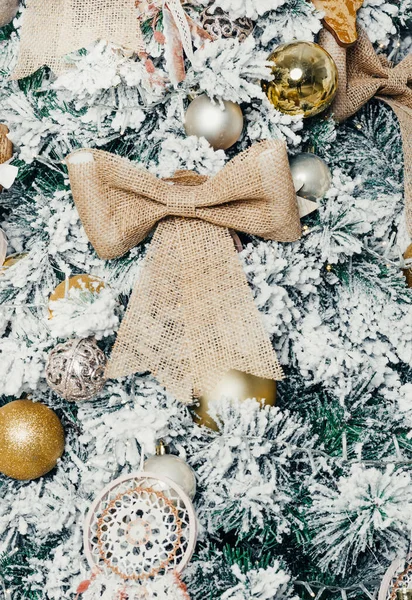 Toplar ve oyuncaklarla süslenmiş büyük bir Noel ağacı Noel hediyeleri ve kurdeleler.