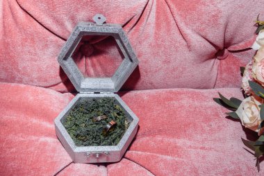 Kutuda beyaz altın alyanslar ve bir buket narin gül ve yeşillik.