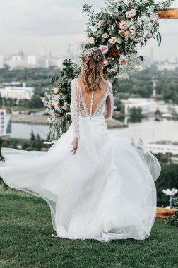 Havadar, beyaz bir gelinlik içinde hoş, genç, narin bir gelin dantelli bir gülücük nazikçe