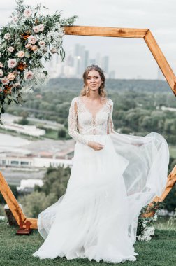 Havadar, beyaz bir gelinlik içinde hoş, genç, narin bir gelin dantelli bir gülücük nazikçe