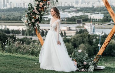 Havadar, beyaz bir gelinlik içinde hoş, genç, narin bir gelin dantelli bir gülücük nazikçe