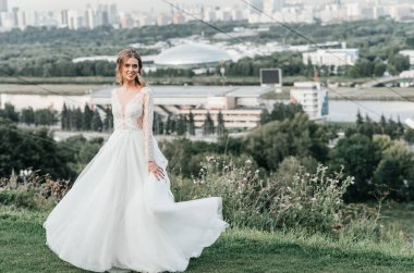 Havadar, beyaz bir gelinlik içinde hoş, genç, narin bir gelin dantelli bir gülücük nazikçe