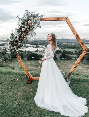 Havadar, beyaz bir gelinlik içinde hoş, genç, narin bir gelin dantelli bir gülücük nazikçe