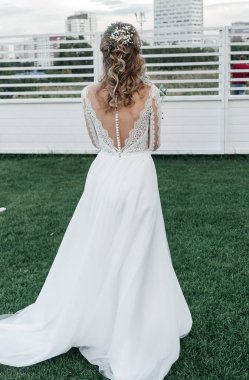 Havadar, beyaz bir gelinlik içinde hoş, genç, narin bir gelin dantelli bir gülücük nazikçe