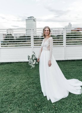 Havadar, beyaz bir gelinlik içinde hoş, genç, narin bir gelin dantelli bir gülücük nazikçe