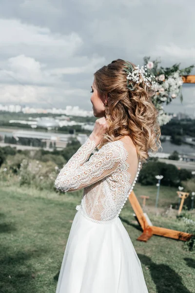 Hermosa hermosa novia delgada joven en un vestido de novia blanco elegante aireado con sonrisa de encaje suave —  Fotos de Stock