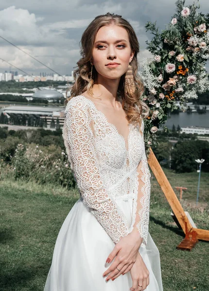 Hermosa hermosa novia delgada joven en un vestido de novia blanco elegante aireado con sonrisa de encaje suave —  Fotos de Stock