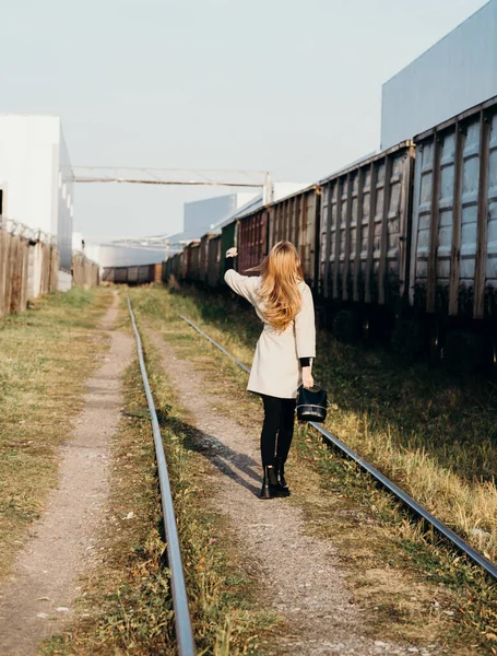 young woman girl hanging on the wagon of a freight freight train green. transportation