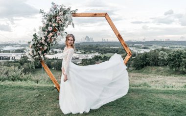 Havadar, beyaz bir gelinlik içinde hoş, genç, narin bir gelin dantelli bir gülücük nazikçe