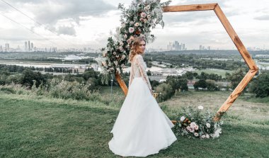 Havadar, beyaz bir gelinlik içinde hoş, genç, narin bir gelin dantelli bir gülücük nazikçe