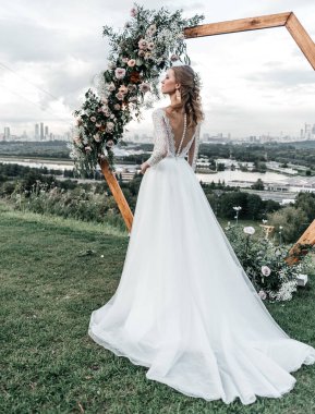 Havadar, beyaz bir gelinlik içinde hoş, genç, narin bir gelin dantelli bir gülücük nazikçe