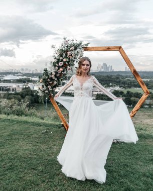 Havadar, beyaz bir gelinlik içinde hoş, genç, narin bir gelin dantelli bir gülücük nazikçe