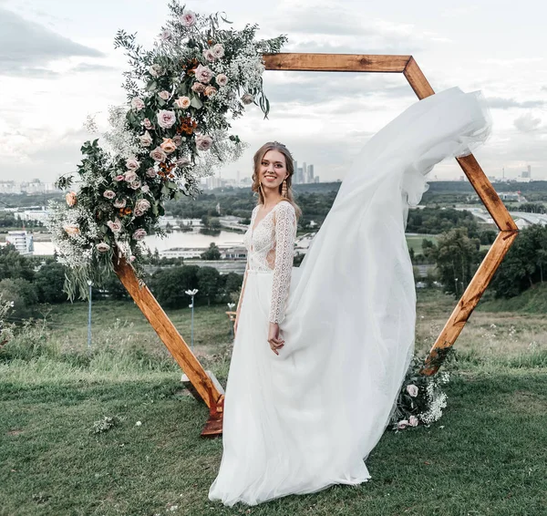 Hermosa hermosa novia delgada joven en un vestido de novia blanco elegante aireado con sonrisa de encaje suave —  Fotos de Stock