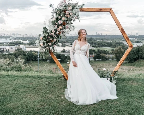 Hermosa hermosa novia delgada joven en un vestido de novia blanco elegante aireado con sonrisa de encaje suave —  Fotos de Stock