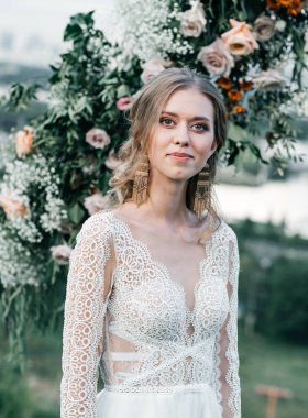 Havadar, beyaz bir gelinlik içinde hoş, genç, narin bir gelin dantelli bir gülücük nazikçe