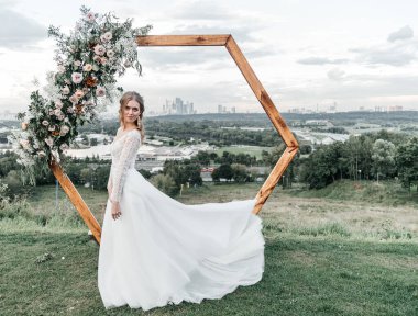 Havadar, beyaz bir gelinlik içinde hoş, genç, narin bir gelin dantelli bir gülücük nazikçe