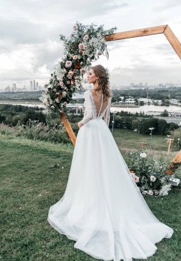 Havadar, beyaz bir gelinlik içinde hoş, genç, narin bir gelin dantelli bir gülücük nazikçe