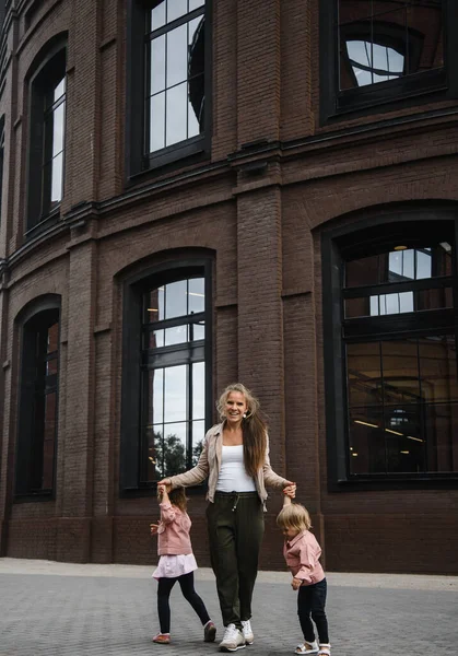 Ung vacker mor med långt hår med barn på promenad i gatan lycka glädje nöje moderskap — Stockfoto