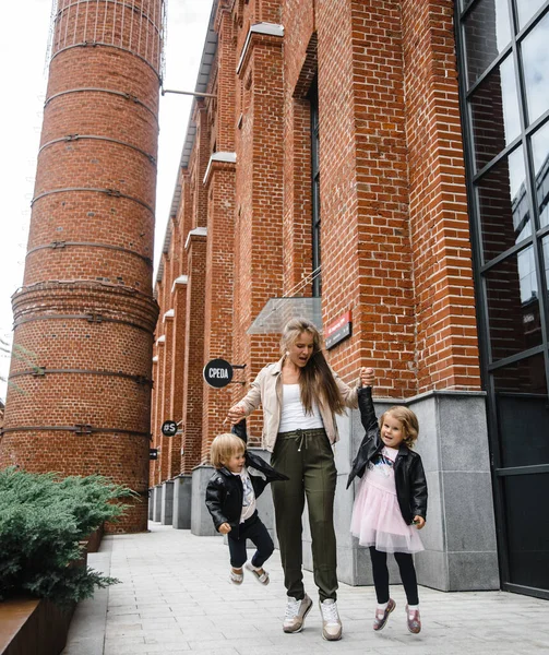 Jovem bela mãe com cabelos longos com crianças no passeio na rua felicidade alegria diversão maternidade — Fotografia de Stock