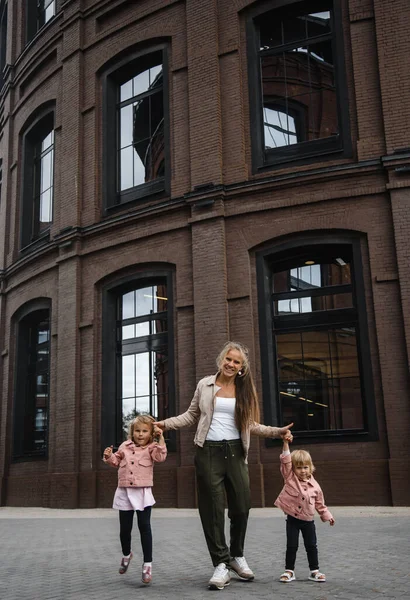 Ung vacker mor med långt hår med barn på promenad i gatan lycka glädje nöje moderskap — Stockfoto