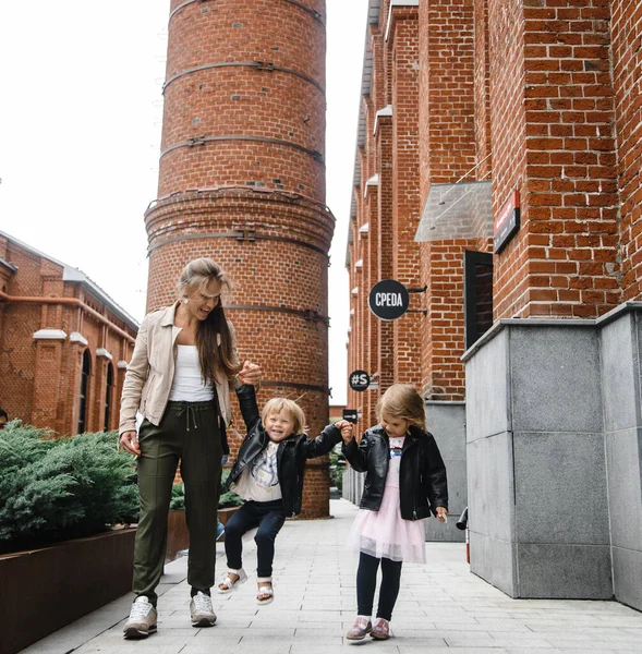 Ung vacker mor med långt hår med barn på promenad i gatan lycka glädje nöje moderskap — Stockfoto