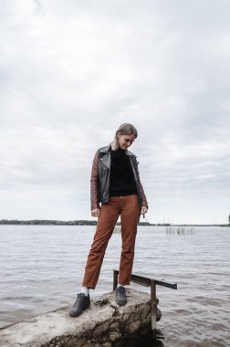 Su nehrinin kıyısında genç bir kadın. Sonbahar su kaynağı. Su derisi.