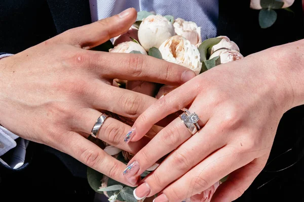 Hände junger Leute mit Eheringen. Details zum Hochzeitstag. Calla-Blumen. Ehepartner — Stockfoto